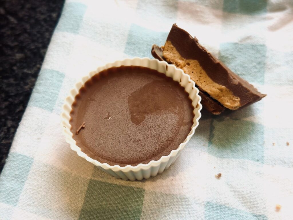 Frozen Peanut butter cup on a towel with a cross section of another stacked against it
