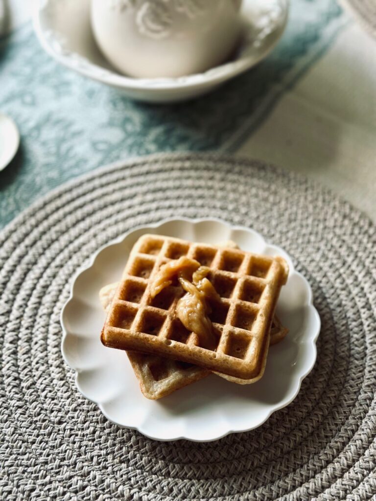 A plate of sourdough waffles on a placemat with a jug in the background