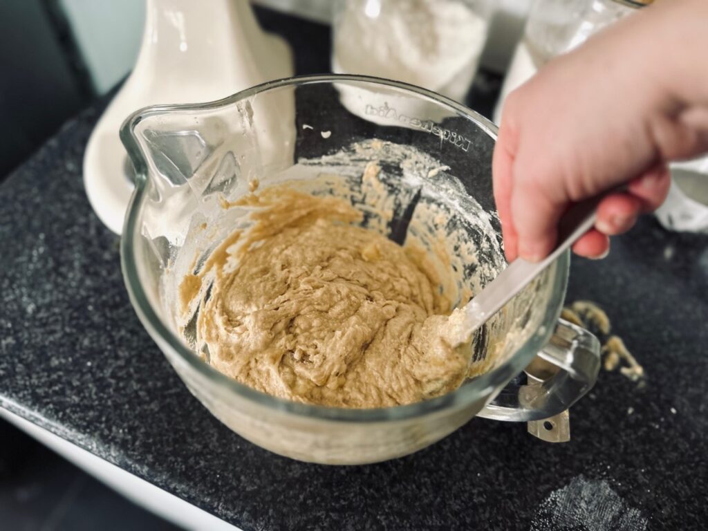 A glass bowl with batter being stirred