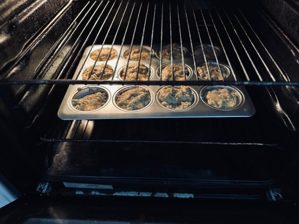 a muffin tin tin full of batter in an open oven