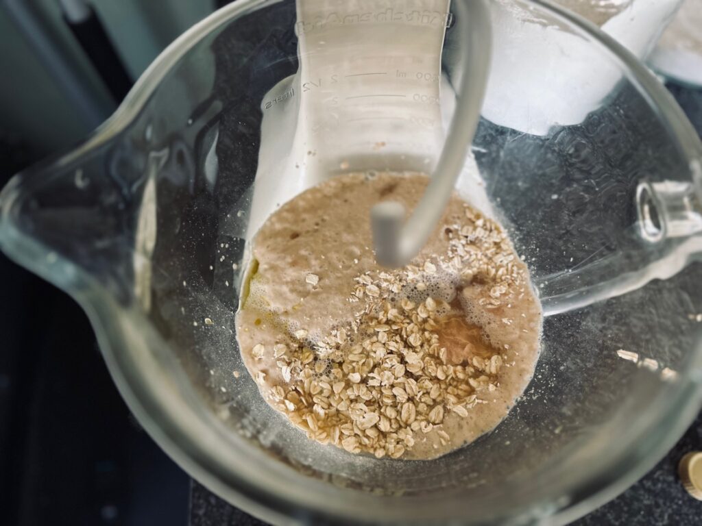 A mixing bowl with oats and liquid