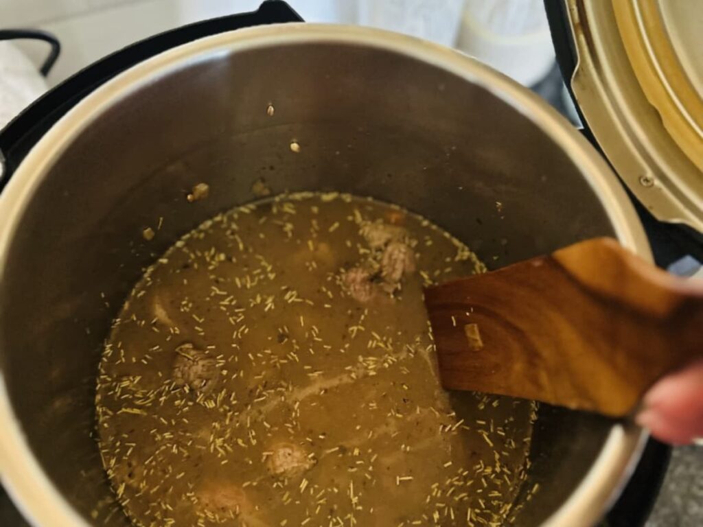 A broth with meat and seasoning in an instant pot