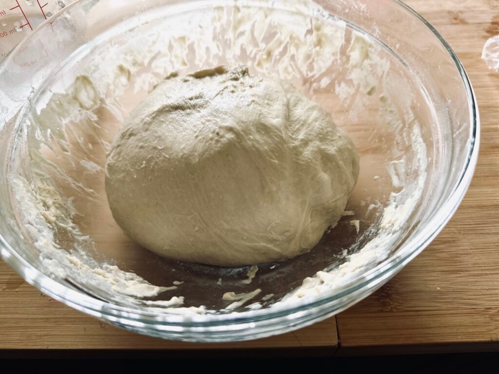 A ball of sourdough in a glass bowl