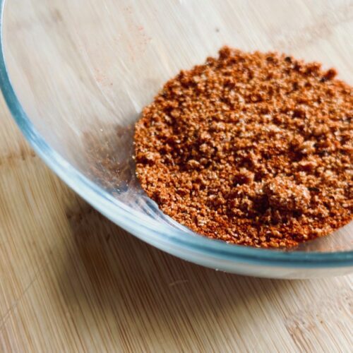 A glass bowl of terracotta powder on a wooden surface