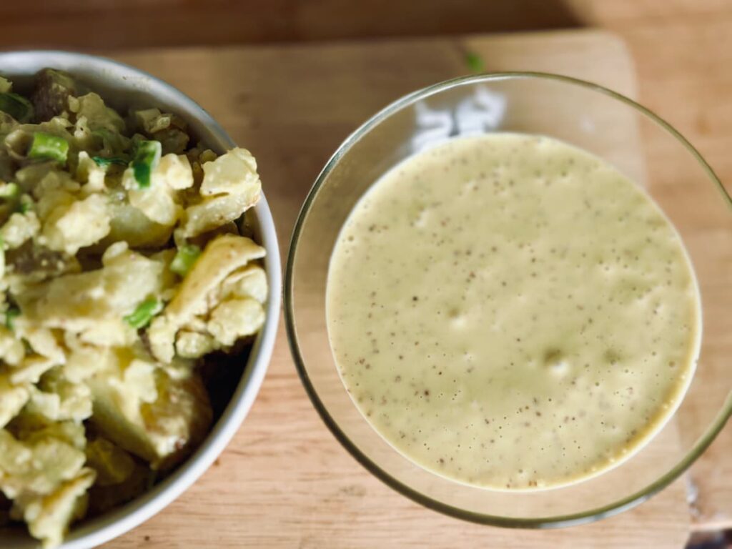 a bowl of homemade mayonnaise next to a bowl of homemade potato salad