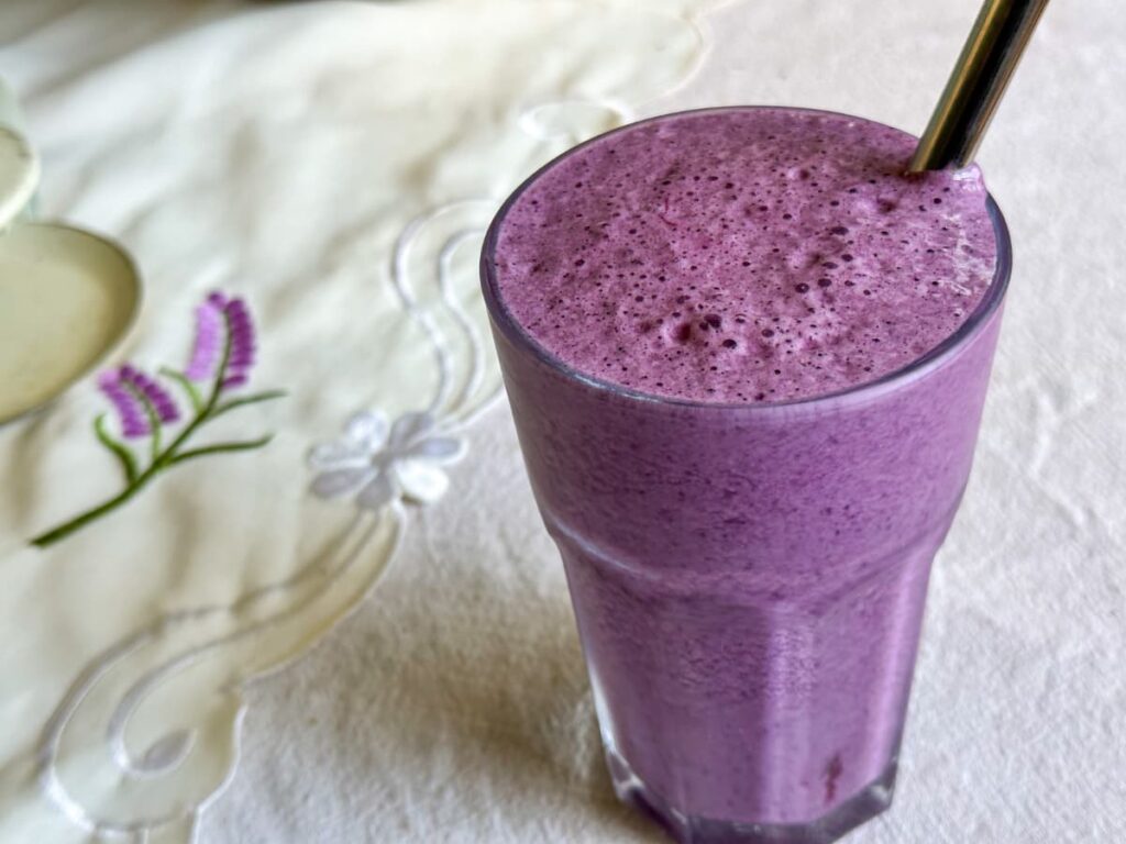 A glass of purple smoothie to show the top 3 delicious summer smoothie recipes 2023