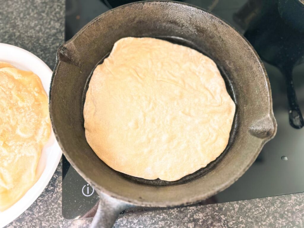 Sourdough tortilla cooking in a cast iron pan