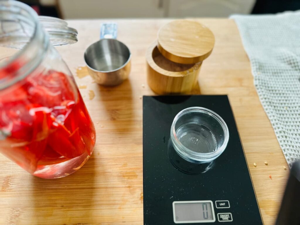 A digital scale set up to weigh salt for fermented peppers for hot sauce.