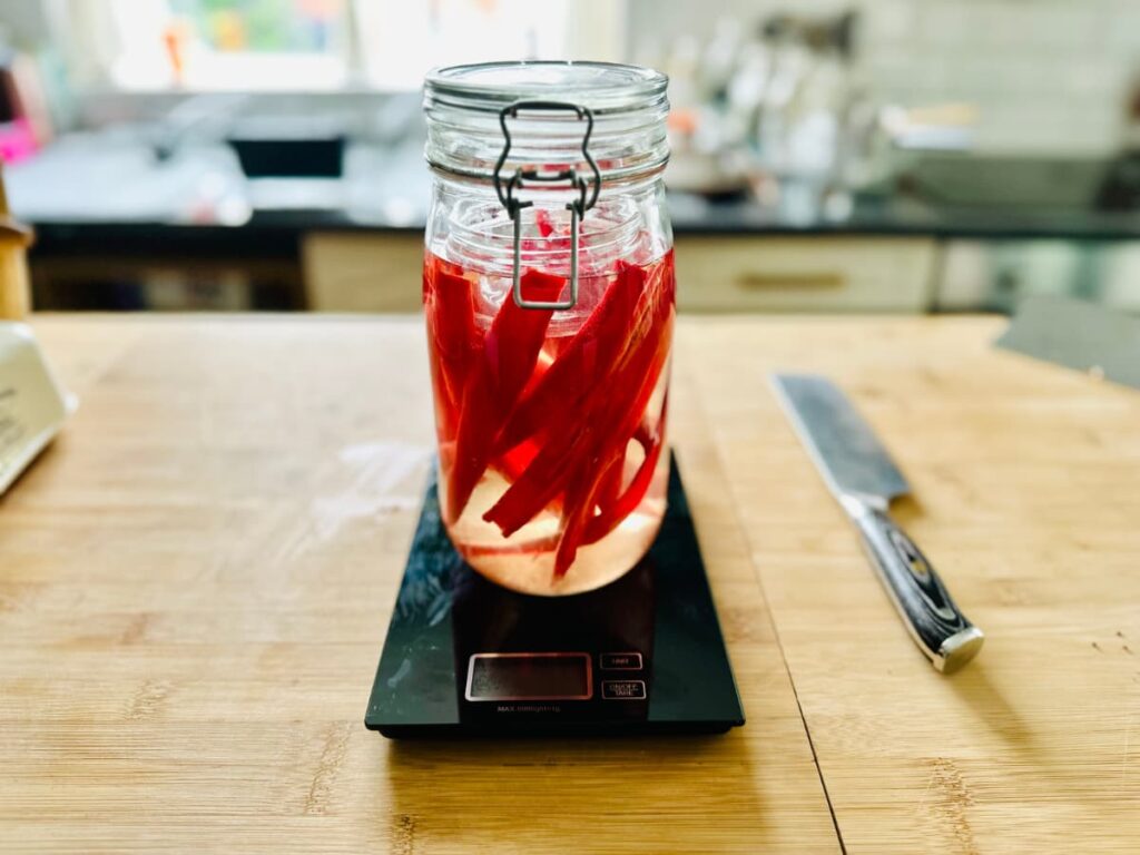 A Jar of red chillies on a digital scale