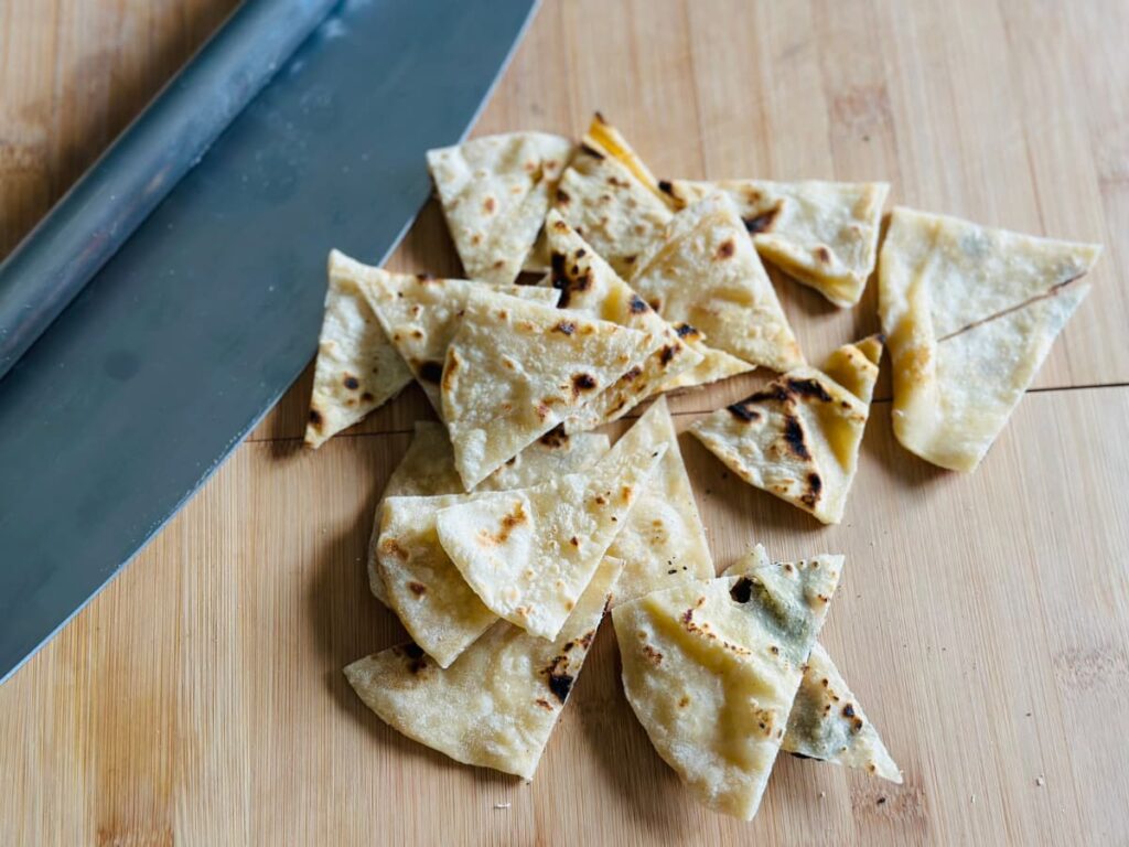 Tortilla wraps cut into wedges next to a chopping blade