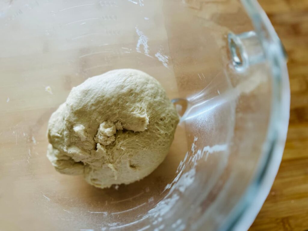 A ball of dough in a glass bowl
