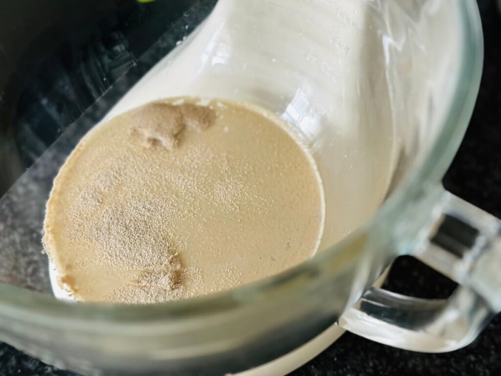 A bowl with yeast, sugar and water inside