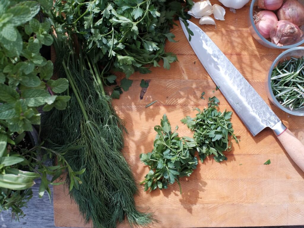 Herbs on a chopping board with a knife