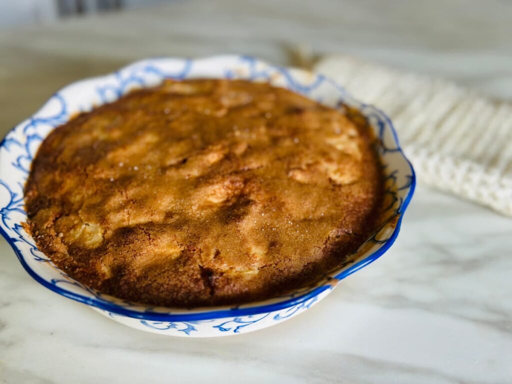 A cooked French apple cake in a pie dish