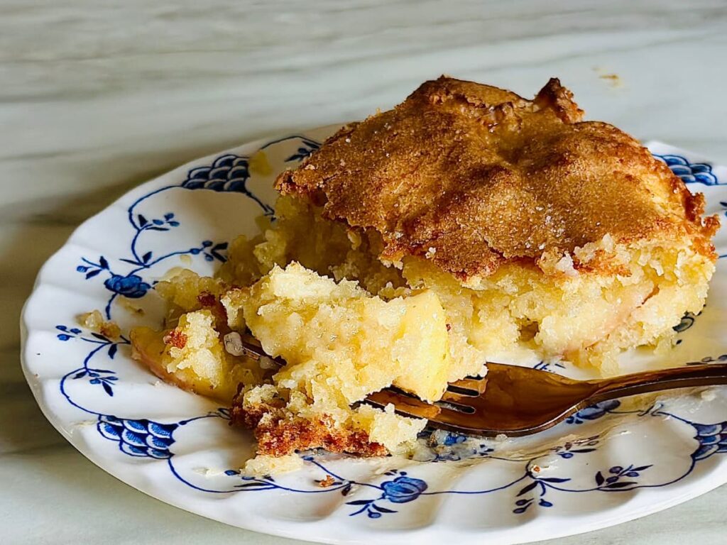 A slice of Easy French apple cake on a blue and white plate