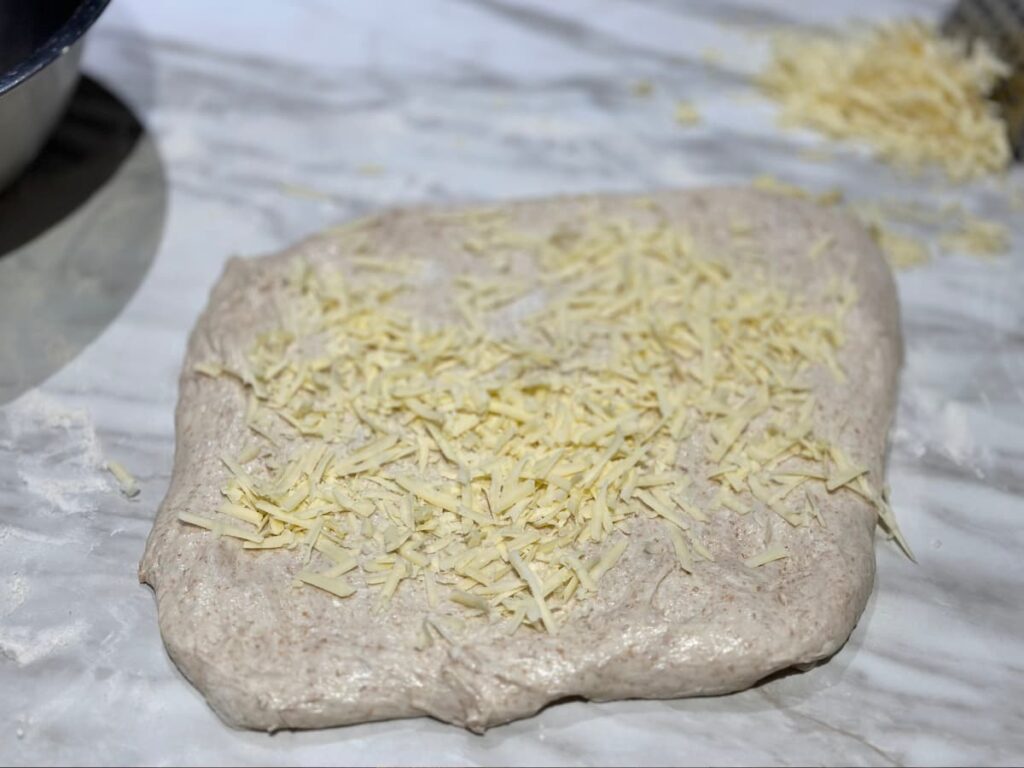 Rectangle of dough covered with grated cheese