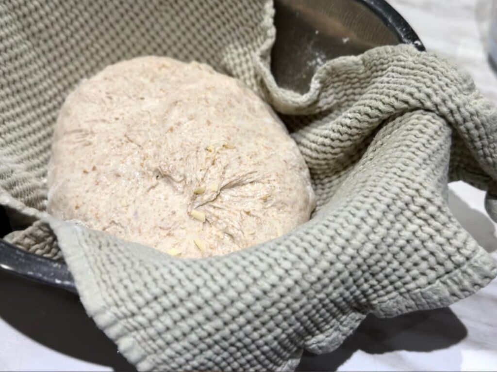 Dough in a tea towel lined bowl