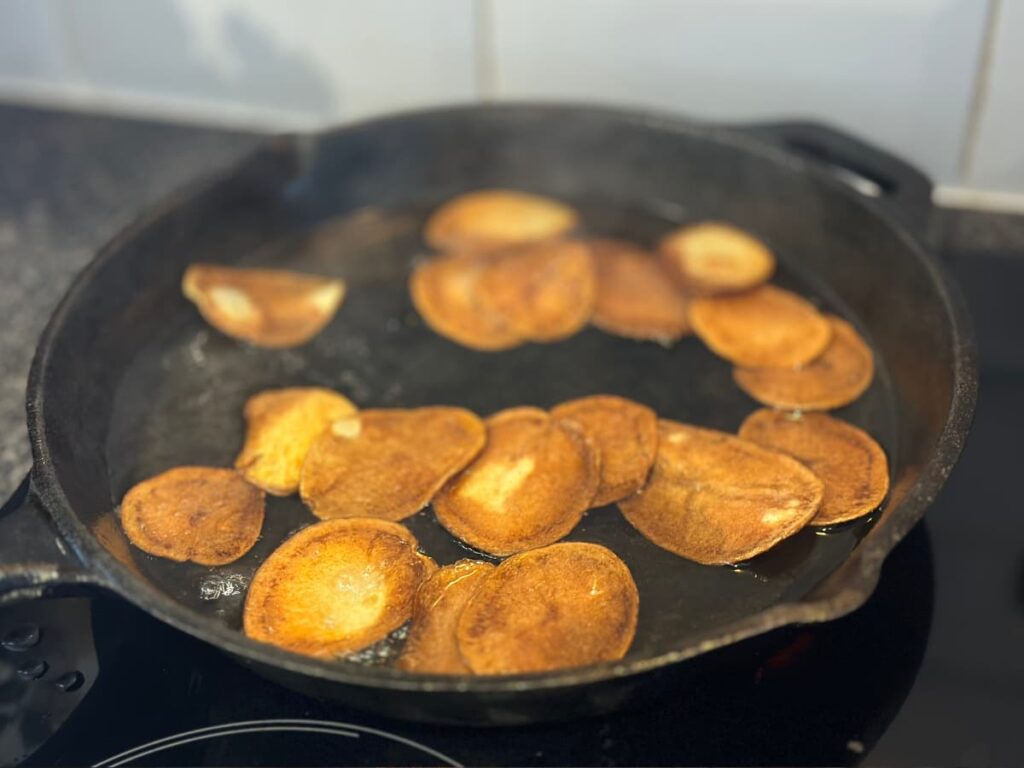 Browned potato slices in a cast iron pan
